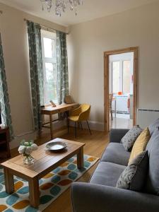 a living room with a couch and a table at Postman's Knock, Lynmouth, first floor apartment with private parking in Lynmouth