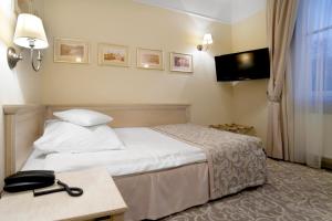 a hotel room with a bed and a television at Branicki Boutique Rooms in Białystok