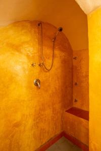 a bathroom with a shower with a hose on the wall at Dammuso Cappero in Pantelleria