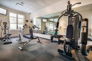 - une salle de sport avec plusieurs vélos d'exercice et un miroir dans l'établissement Imperia Hôtel et Suites Terrebonne, à Terrebonne