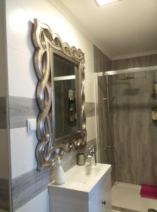 a bathroom with a mirror and a sink and a shower at AP TORRE in Torre de Moncorvo