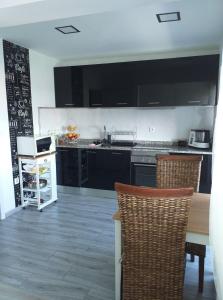 a kitchen with black cabinets and a table and chairs at AP TORRE in Torre de Moncorvo