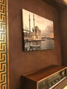 a painting of a building and a boat on the water at Paris Garden Hotel Istanbul in Istanbul