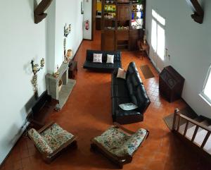 una vista aérea de una sala de estar con muebles de cuero negro en Casa Dona Beatriz, en Furnas