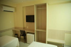 a room with a table, chairs, and a television at Stay Inn Hotel in Imperatriz