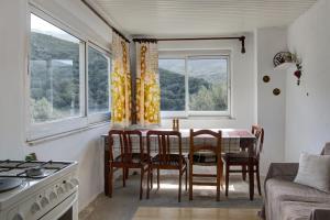 a kitchen with a table and chairs and windows at Traditional Cretan Country House (9klm from Elafonissi) in Plokamianá
