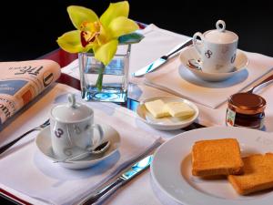 a table with plates of food and cups and bread at L'O Venezia Flat - WTB Hotels in Venice
