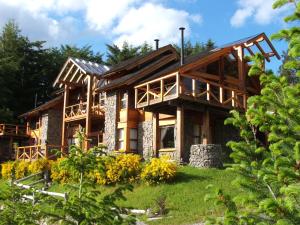 una casa de madera con un gambrel en Colina Del Manzano en Villa La Angostura