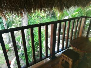 a balcony of a resort with a table and a tree at Casa CheJum Bacalar in Bacalar