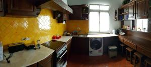 una cocina con fregadero y lavadora en Casa Dona Beatriz, en Furnas