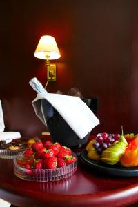 a table topped with plates of fruit and a paper at Hotel Kalliohovi in Rauma