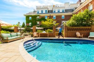a young boy walking by a swimming pool at The Vanderbilt, Auberge Collection in Newport