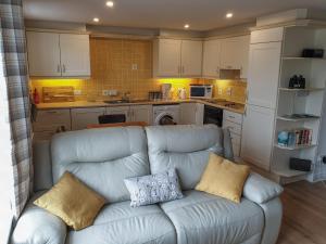 Coastal View في بوشميلس: غرفة معيشة مع أريكة في مطبخ +15 صورة