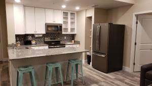 a kitchen with a black refrigerator and two stools at Barefoot Beach Club in St. Pete Beach