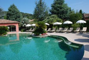 uma piscina com cadeiras e guarda-sóis num resort em Domaine De Respelido em Carros
