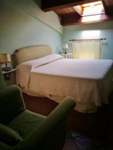 a bedroom with a large bed and a chair at La Zizzania e il Mandarino in Roccagloriosa