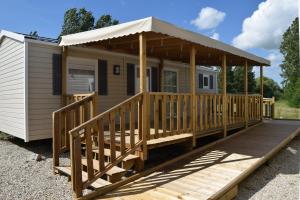 a mobile home with a porch and a gazebo at Camping des Joyeux Campeurs in Pont-sur-Seine