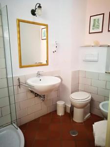 y baño con lavabo, aseo y espejo. en La Zizzania e il Mandarino, en Roccagloriosa