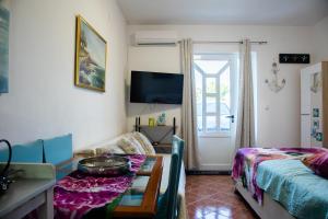 een woonkamer met een tafel en een bed bij Villa Scandalli in Sevid
