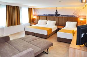 伊斯坦堡的住宿－伊斯坦布爾達沃斯酒店，酒店客房,设有两张床和一张沙发