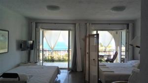 a bedroom with two beds and a balcony with the ocean at Dalmacija Gradac in Gradac