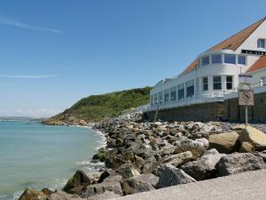 a building on a rocky beach next to the water at Gîte les Hortensias in Marquise