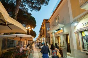 un grupo de personas caminando por una calle de la ciudad en Amnis suites, en Santa Maria di Castellabate