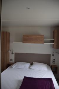 سرير أو أسرّة في غرفة في Camping des Joyeux Campeurs