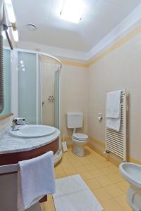 a bathroom with a tub and a toilet and a sink at Albergo Roma in Tolmezzo