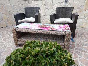 2 rieten stoelen en een tafel in een patio bij Villa Scandalli in Sevid