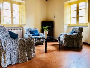 ein Wohnzimmer mit 2 Stühlen und einem Couchtisch in der Unterkunft La vecchia canonica in Fivizzano