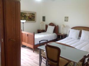 1 Schlafzimmer mit 2 Betten, einem Tisch und einem Sofa in der Unterkunft Le Gros Chigy Château in Saint-André-le-Désert