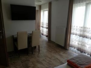 a dining room with a table and chairs and a television at Haus Alexis in Faak am See