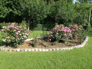 a circular garden with pink flowers in a yard at Guesthouse Šebalj in Rakovica