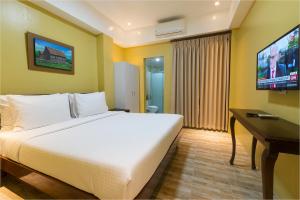 a hotel room with a bed and a television at Bernardo's Lantia Hotel in Basco