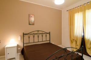 1 dormitorio con 1 cama y una ventana con cortinas amarillas en DIMORA ALFAS, en Borgagne