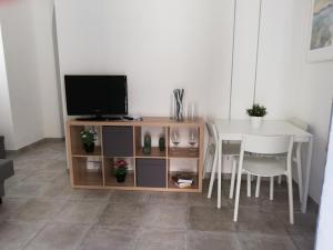 a television sitting on a stand next to a table at Casa Vacanze Scicli Centro in Scicli