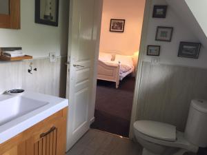 a bathroom with a sink and a toilet and a bedroom at LE CLOS DU GOLF in Dame-Marie-les-Bois