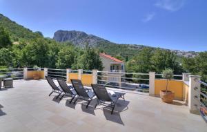 a row of chairs on a patio with mountains in the background at Apartments Stipe in Lukovo
