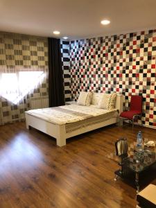 1 dormitorio con 1 cama en una habitación con una pared a cuadros en Vale hotel&restaurant complex en Gyumri