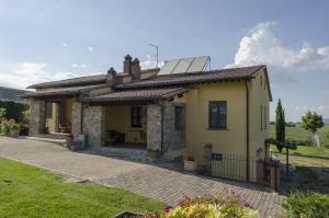 una pequeña casa amarilla con techo en Agriturismo Lodolazzo, en Cortona