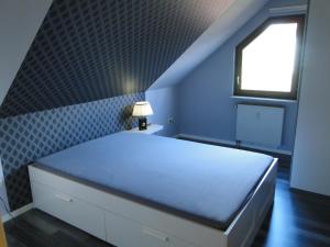 a blue bedroom with a bed and a window at Ferienwohnung Am Klosterberg 6 in Bad Brückenau
