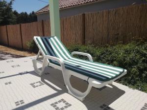 una sedia verde e bianca seduta su un patio di Villa Gonçalo a Caldas da Rainha