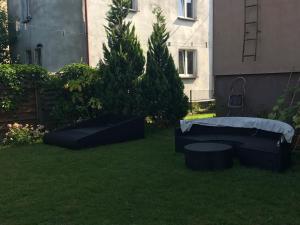 a yard with two beds and a table and trees at Pokoje przy basenie in Giżycko