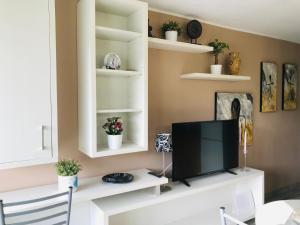 een woonkamer met een tv op een witte plank bij HOME LOS ELEFANTES in Playa del Inglés