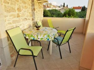 a table and four chairs on a balcony at Studio apartmani Šverko in Punat