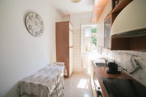 kuchnia ze zlewem i zegarem na ścianie w obiekcie Villetta Margherita w Rapallo