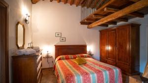 um quarto com uma cama, uma cómoda e um espelho em Poggio Al Palio em San Lorenzo a Merse