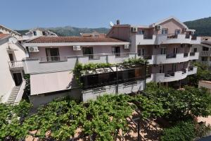 um edifício de apartamentos com plantas nas varandas em Guest House Zec em Budva