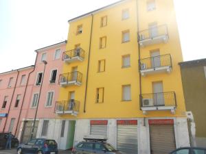 un edificio giallo con macchine parcheggiate di fronte di Residence Piemonte a Sesto San Giovanni